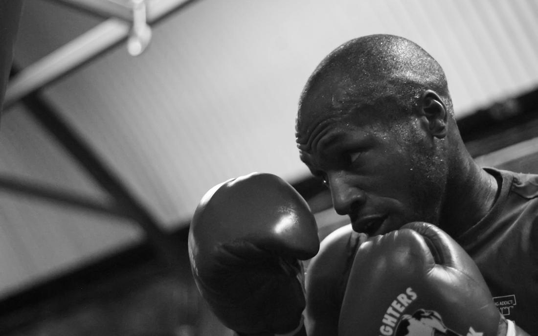 An amateur boxer with gloves up in a gym