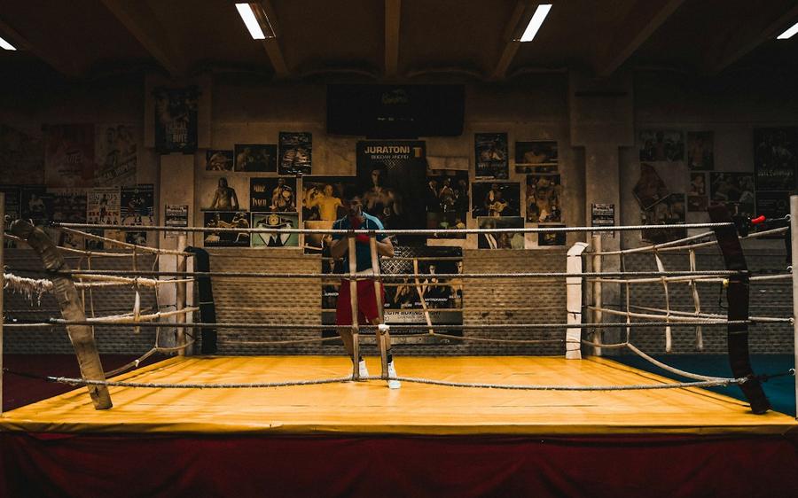 A boxing club ring with a coach and boxer training