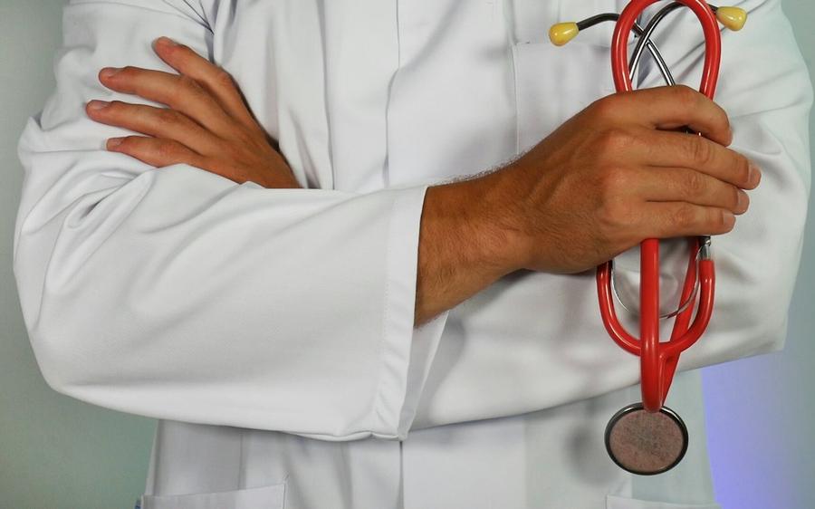 A doctor holding a red stethoscope